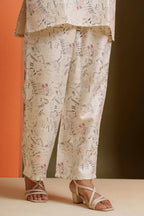 Cream viscose co-ord set with newspaper print, paired with strappy heels for stylish everyday wear