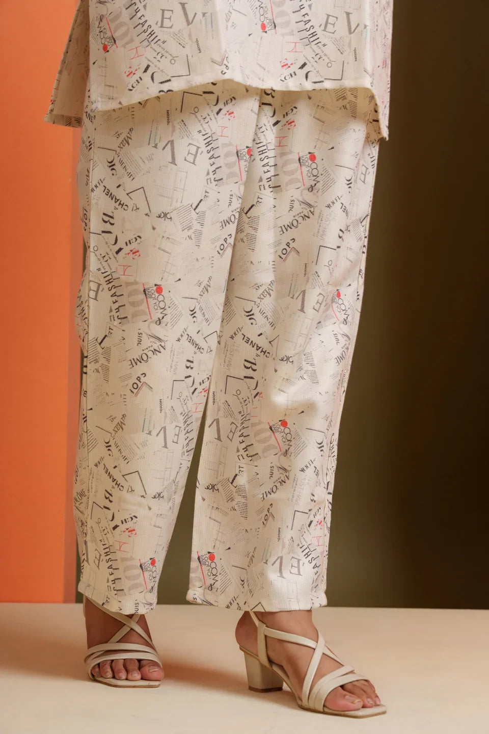 Cream viscose co-ord set with newspaper print, paired with strappy heels for stylish everyday wear