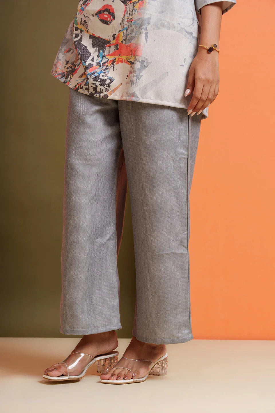 Grey wide-leg pants with abstract print top, styled for modern everyday wear or festive occasions.